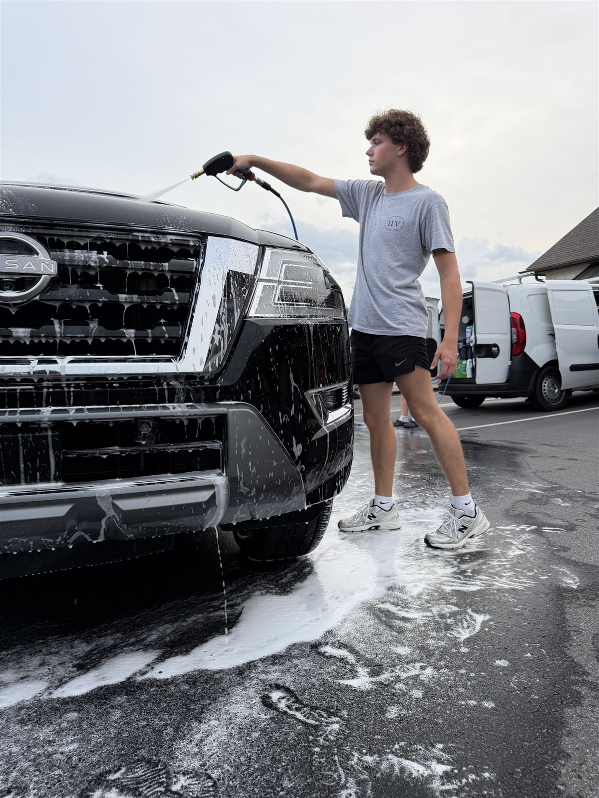 Palmetto Auto Detail technician foam-washing a black truck on location
